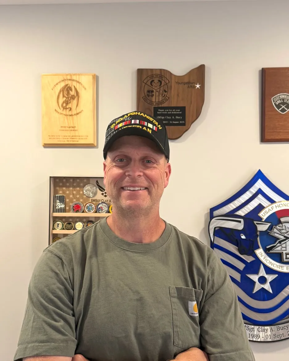 Clay Bucy, owner of Mission Ready Repairs, in front of his U.S. Air Force service plaques